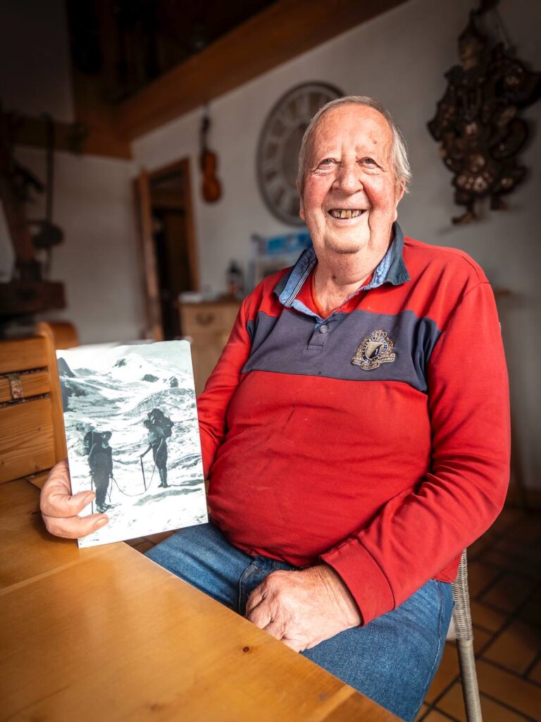 Michel Erba, avec une photo de son grand père, qui était guide-porteur.